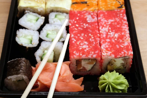 Sushi op vierkante dienblad op bruin houten tafel kant weergave closeup — Stockfoto