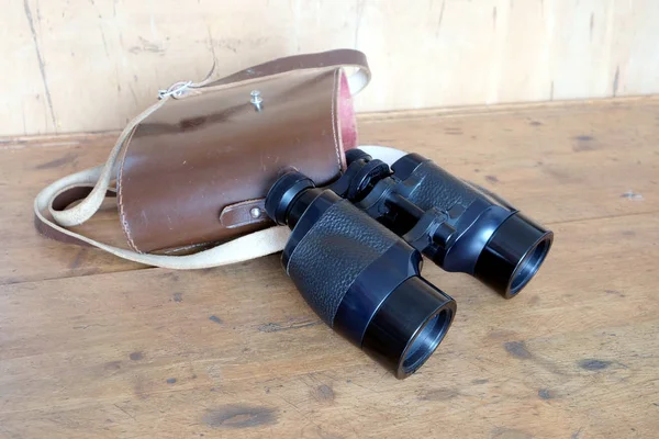 黑色的老式棱镜颜色双筒望远镜和棕色皮套 — 图库照片