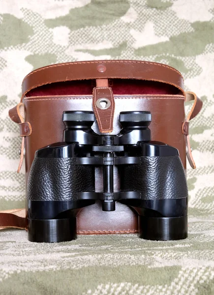 老式 Porro 棱镜黑色双筒望远镜与伪装背景情况 — 图库照片