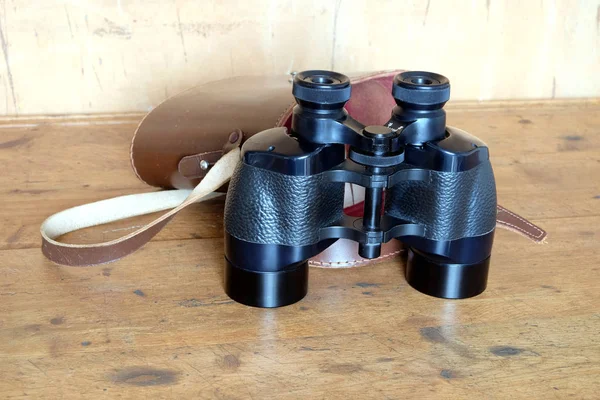 黑色的老式棱镜颜色双筒望远镜和棕色皮套 — 图库照片