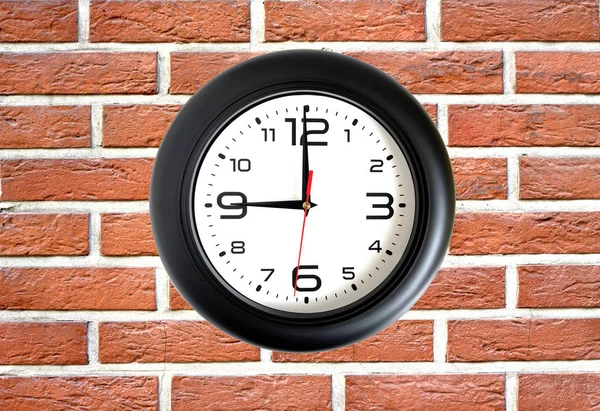 Big round clock on red brick wall closeup