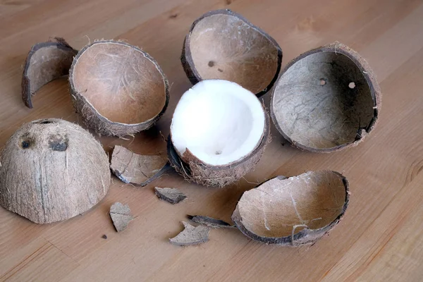 Casca de coco esmagada e fruta de coco em fundo de madeira — Fotografia de Stock