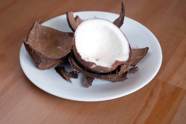 Casca de coco esmagada e fruta de coco em close-up placa branca — Fotografia de Stock