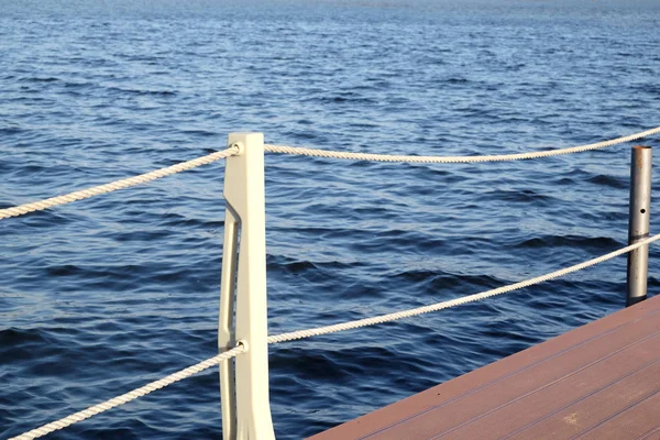 La partie du quai et la clôture avec des cordes de la surface de l'eau — Photo