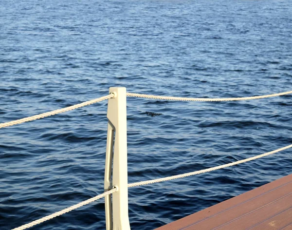 The part of the quay and the fencing with ropes from the water surface — Stock Photo, Image