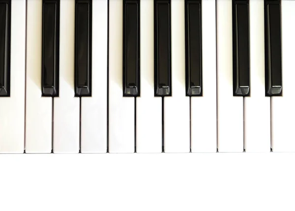 与白键和黑键的钢琴键盘白色背景上的顶视图 — 图库照片