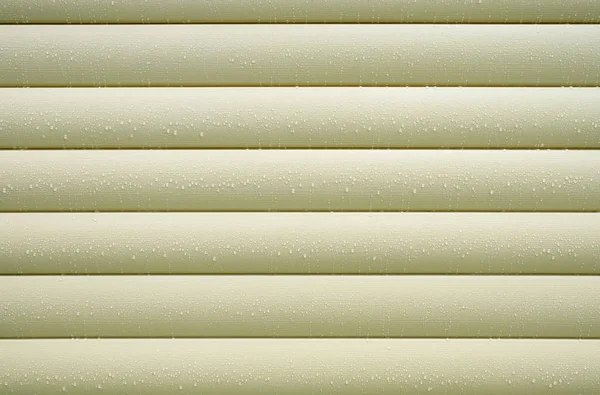 Wall covered with beige siding with many water drops after rain closeup as background — Stock Photo, Image