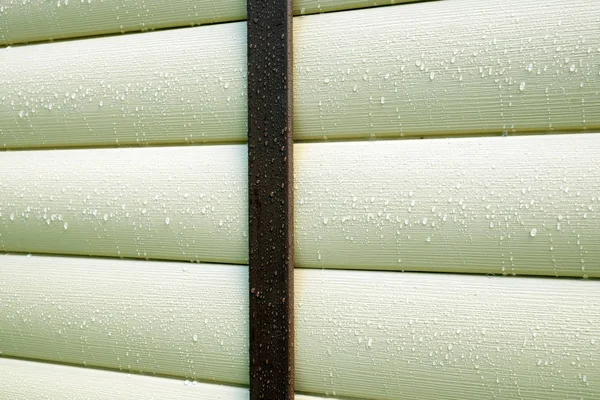 Building wall covered with beige siding panels protect house wall — Stock Photo, Image