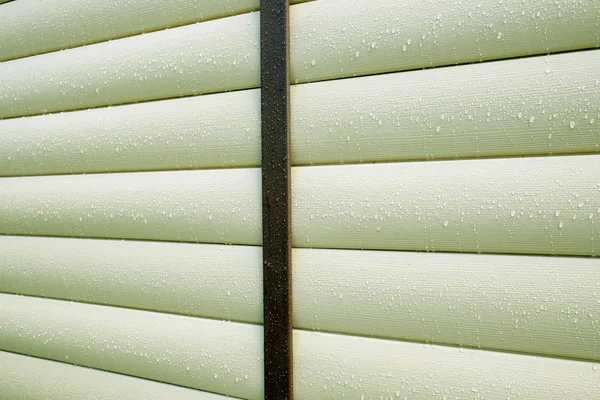 Byggnaden vägg täckt med beige rangerbangård paneler skydda husvägg — Stockfoto