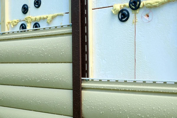 Abstellgleise montieren bei Regen über Isolierung an Hauswand — Stockfoto