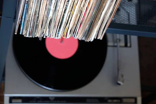 Montón de muchos discos de vinilo en cubiertas viejas y tocadiscos en caja gris — Foto de Stock