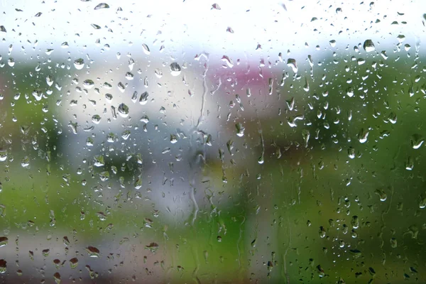 Капли дождя на оконное стекло в дождливый осенний день крупным планом — стоковое фото