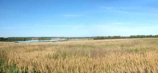 Hermoso paisaje rural con colinas, lago, un pueblo y una iglesia cristiana lejos en verano —  Fotos de Stock