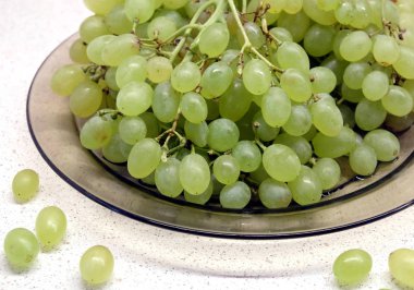 Demet şeffaf plaka mutfak masa portre üzerinde olgunlaşmış Yeşil üzüm