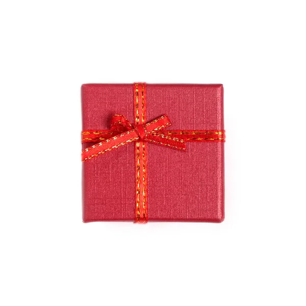 Натюрморт з святковим подарунком у маленькій червоній коробці, вкритій стрічкою з бантом ізольовані на білому тлі вид зверху — стокове фото