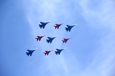 Moskova, Rusya - 9 Mayıs 2015: Mavi gökyüzü karşı geçit uçuş Mig-29 ve Su-27 savaşçıları hafif bulutlu 9 Mayıs 2015 tarihinde Moskova'da Rus Knights ve ebabiller akrobasi grupları