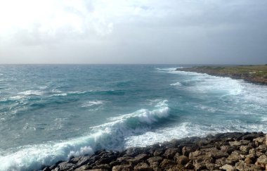 Deniz, yatay yukarı doğru karşı kıyı şeridi beyaz köpük sinek sıçramalarına fırtınalı yaz gününde dalgalar