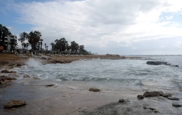 在傍晚时分 在海边的海滨度假胜地有酒店建筑和棕榈树 在波浪的映衬下 — 图库照片