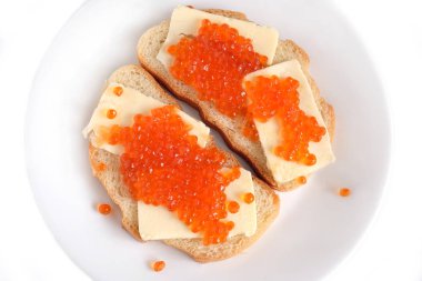 Tereyağı ve üzerinde beyaz ekmek yalan yuvarlak tabakta beyaz arka plan üzerinde üstten görünüm izole kırmızı somon havyar ile iki sandviç