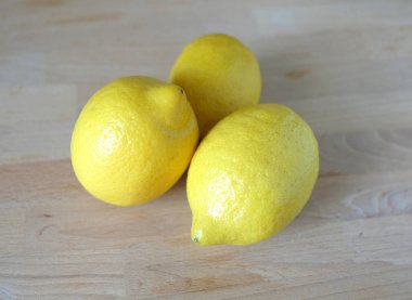 Ahşap arka plan açık görünüm portre üzerinde üç olgun sarı limon ile natürmort