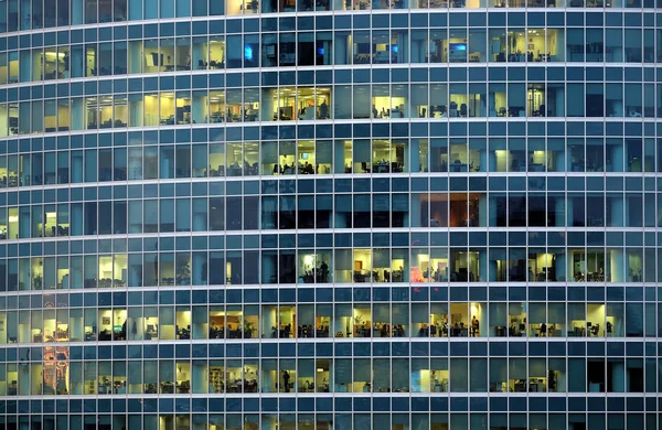 Günümüz Gökdelen Binasının Cephesinde Çalışan Insanlar Akşamları Panoramik Pencereleri Aydınlatıyor — Stok fotoğraf
