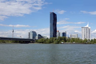 Vienna, Austria - May the 10th 2019: View from Danube to the Imperial bridge, TV tower and Vienna, International Centre in Donaustadt district on bright sunny day