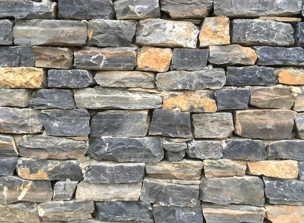 カラフルな天然石のブロックから仕上げフェンスの石造りの作品は バックグラウンドフロントビューのクローズアップとしてトリム — ストック写真
