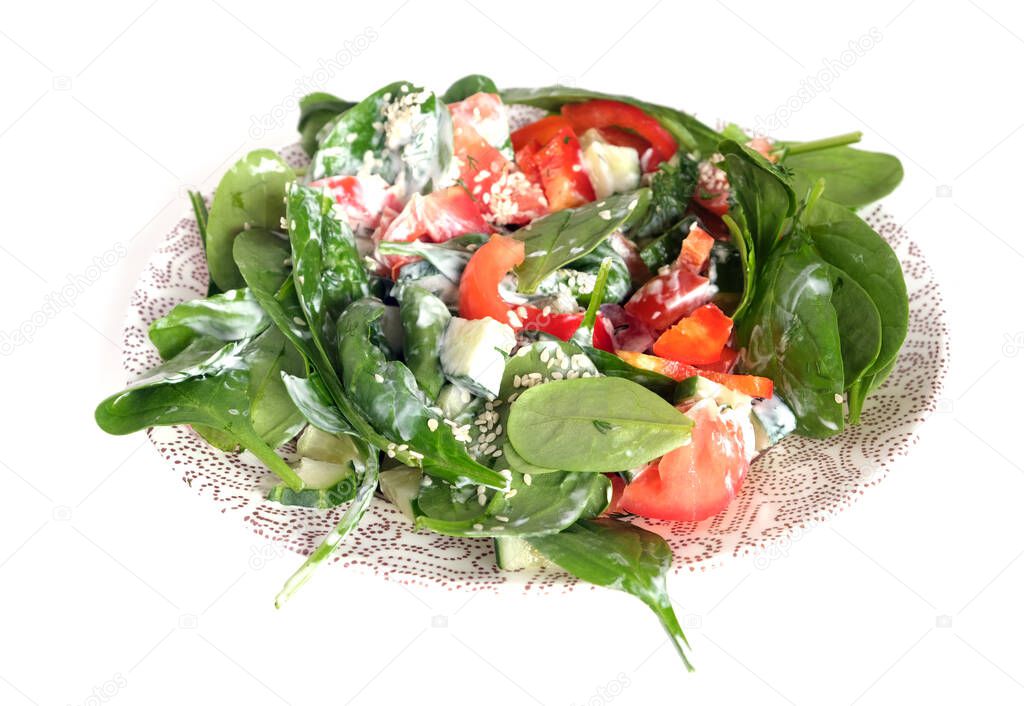Tasty healthy low calorie vegetarian light salad from raw fresh vegetables and yogurt on round white plate isolated on white background front view close up