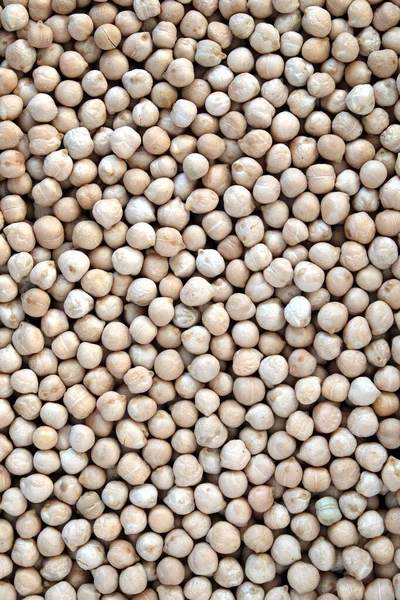 Food supplies. Crop of many dry round beige lentil grains on flat surface as background top view vertical close up