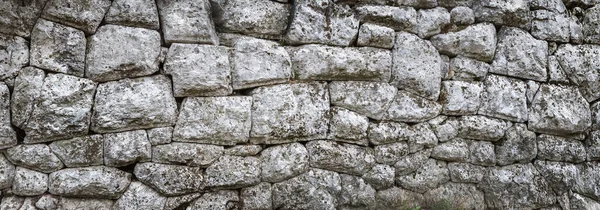 古老的石墙是由自然粗糙的石头制成的 具有冥想的风格 没有水泥的古老石工建筑 其纹理呈石墙状 为您的创作背景提供全景造型 免版税图库图片