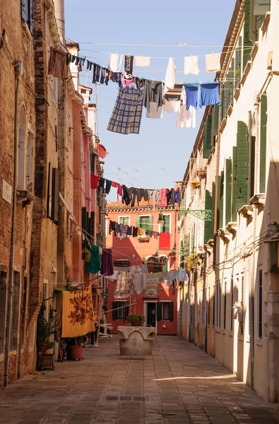 Tradicional calle italiana con ropa colgando a secar betwe —  Fotos de Stock