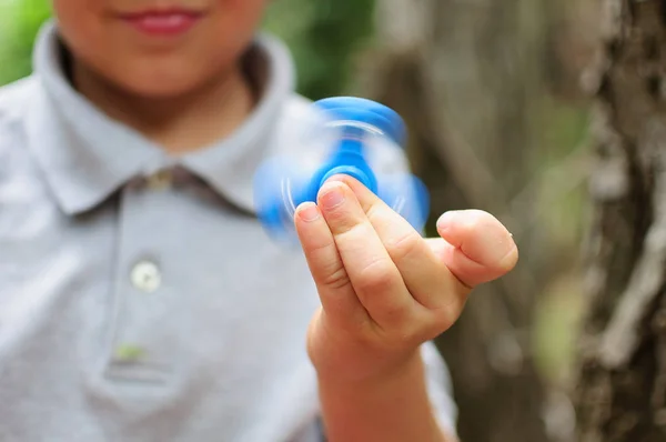 Bir Tri kıpır el Spinner ile oynayan çocuk