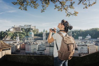 Avusturya. Salzburg. Bir genç turist kız fotoğraf çeker