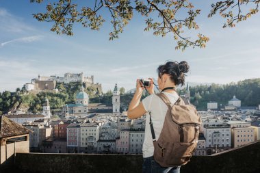 Avusturya. Salzburg. Bir genç turist kız fotoğraf çeker