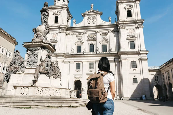 Chica viajero con una mochila cerca de la famosa catedral de Salzburgo — Foto de Stock