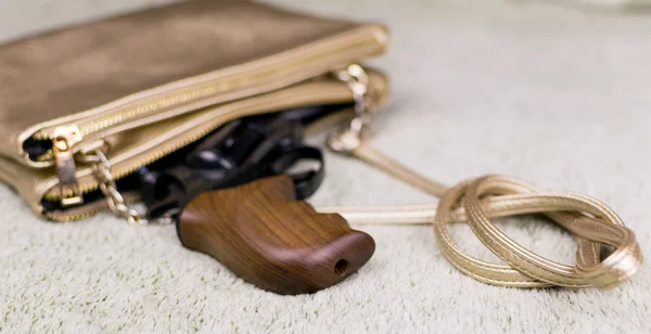 Női önvédelem. Egy pisztoly leskelődik ki egy nő táskájából.. — Stock Fotó