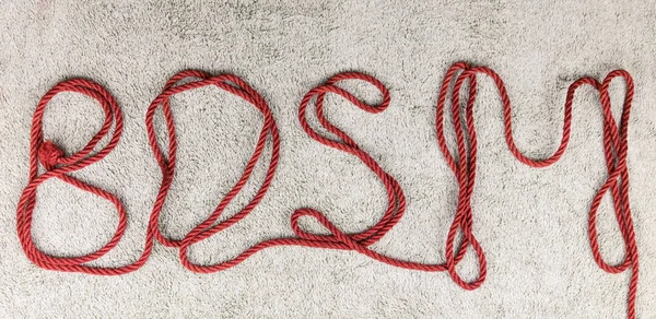 BDSM. Harfler bağlanmak için halattan çıkarılmıştır (shibari).