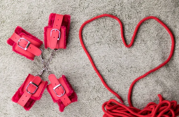 Червоні наручники і мотузка для зв'язування вишиті у формі серця . — стокове фото
