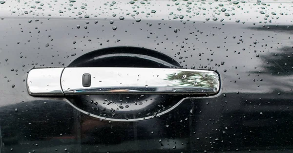 Des gouttes d'eau sur la poignée d'une voiture noire . — Photo