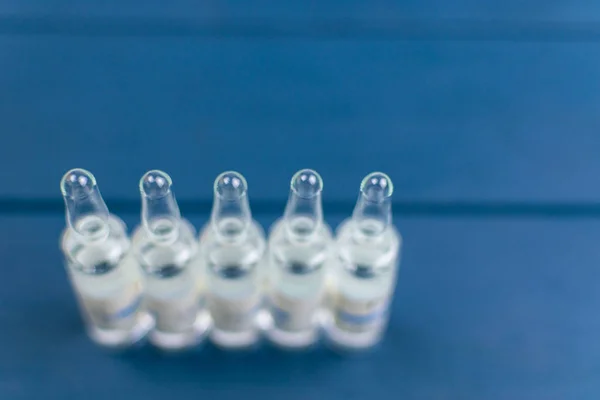 Medical ampoules on a blue background. — Stock Photo, Image