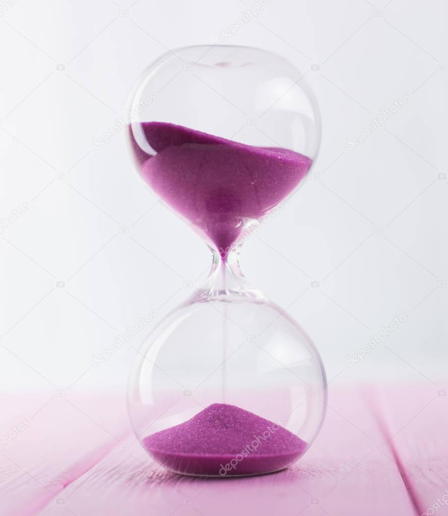 Hourglass with pink sand.