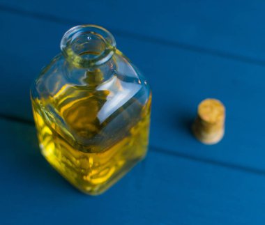 Mavi ahşap arka planda iksiri olan şişe..