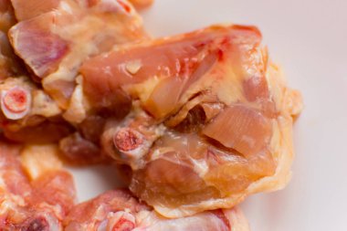 Beyaz tabakta çiğ tavuk butları..