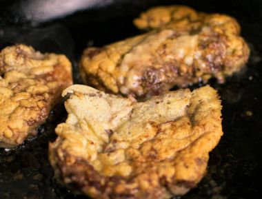 Domuz pirzolası kemiksiz meyilli içinde bir tavada kızarmış.