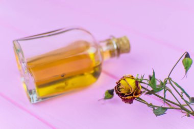 Bir şişe iksiri ile arka planı çiçek kurutulmuş.