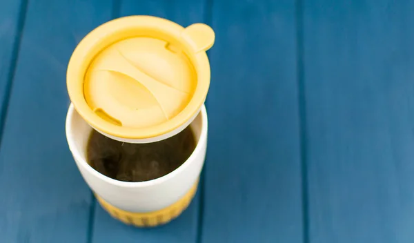 Termo mugg med varmt kaffe på en trä bakgrund. — Stockfoto