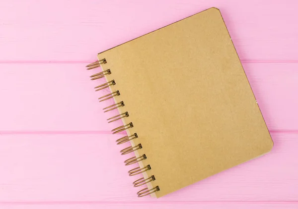 Um caderno de esboços sobre um fundo de madeira rosa . — Fotografia de Stock
