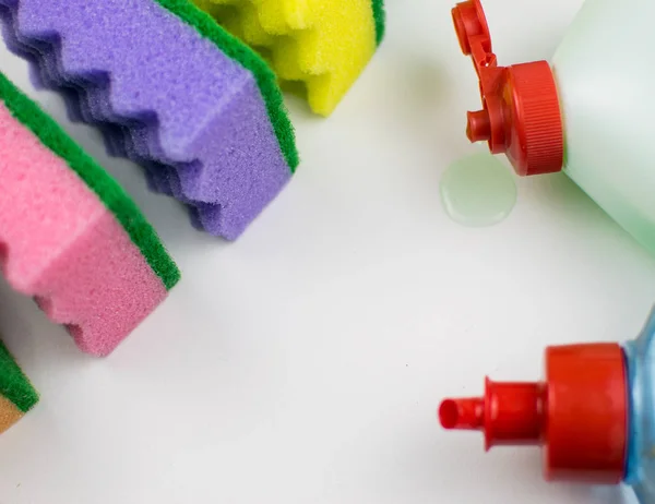 Esponjas de goma multicolores y detergente sobre un fondo claro . —  Fotos de Stock