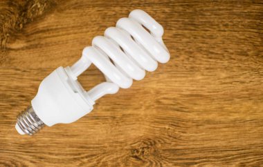 Enerji tasarruflu ampul ahşap bir arka plan üzerinde.