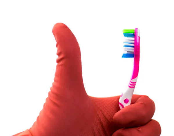 A hand in a rubber glove holds a toothbrush on a white background. Isolated. Hygiene concept. — Stock Photo, Image